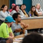 Students and teachers in a seminar classroom in discussion.