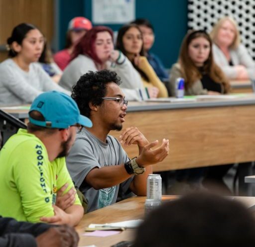 Students and teachers in a seminar classroom in discussion.